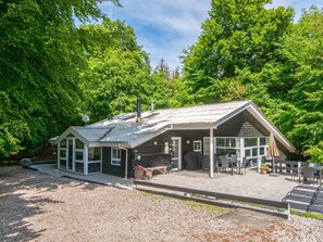 A lodge with a covered patio, a chimney, and a number 23 sign.