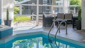 A pool area with a clear view of the outdoors, including a wooden deck and greenery. - 4 Star Holiday Home in Glesborg (Glesborg)
