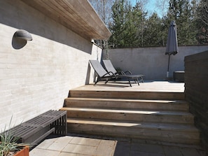 A patio with wooden steps leading to a seating area with two lounge chairs. - Holiday Home in HÃ¸jslev (Hojslev)