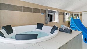 A hot tub with a blue slide, a window with curtains, and a door. - Holiday Home in Kappeln (Kappeln)