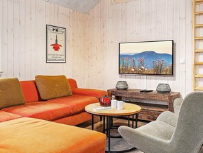 A room with a sofa, armchair, and a table with a teapot and cups. - Holiday Home in Kappeln (Kappeln)