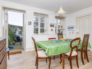 A dining area with a table set for four, surrounded by wooden chairs with cushioned seats. - 5 Person Holiday Home in Logstor (Logstor)