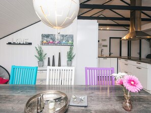 A modern kitchen with white cabinetry, a hanging light fixture, and a wall-mounted picture of colorful cars. - 6 Person Holiday Home in Toftlund (Toftlund)