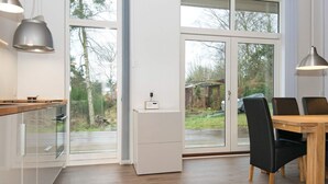 A modern kitchen with a dining area, large windows, and a view of the outdoors. - Holiday Home in Knebel (Knebel)
