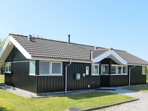 A two-story building with a dark exterior, a tiled roof, and multiple windows. - Holiday Home in Hadsund (Hadsund)
