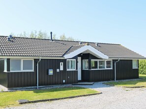 A single-story building with a dark facade, a pitched roof, and a small front porch.