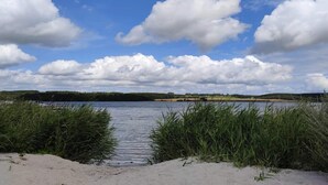 A lake with a clear sky and clouds, surrounded by vegetation. - Holiday Home in Svendborg (Svendborg)
