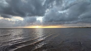 A beach with waves and a cloudy sky.