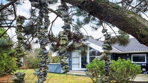 A house with a stone wall and a lawn.