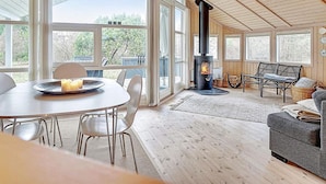 A spacious room with a large dining table, a sofa, and a fireplace.