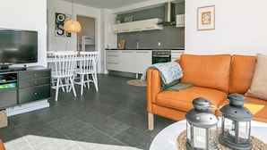 A modern living room with a television, sofa, and decorative lanterns. - Holiday Home in Bogense (Bogense)