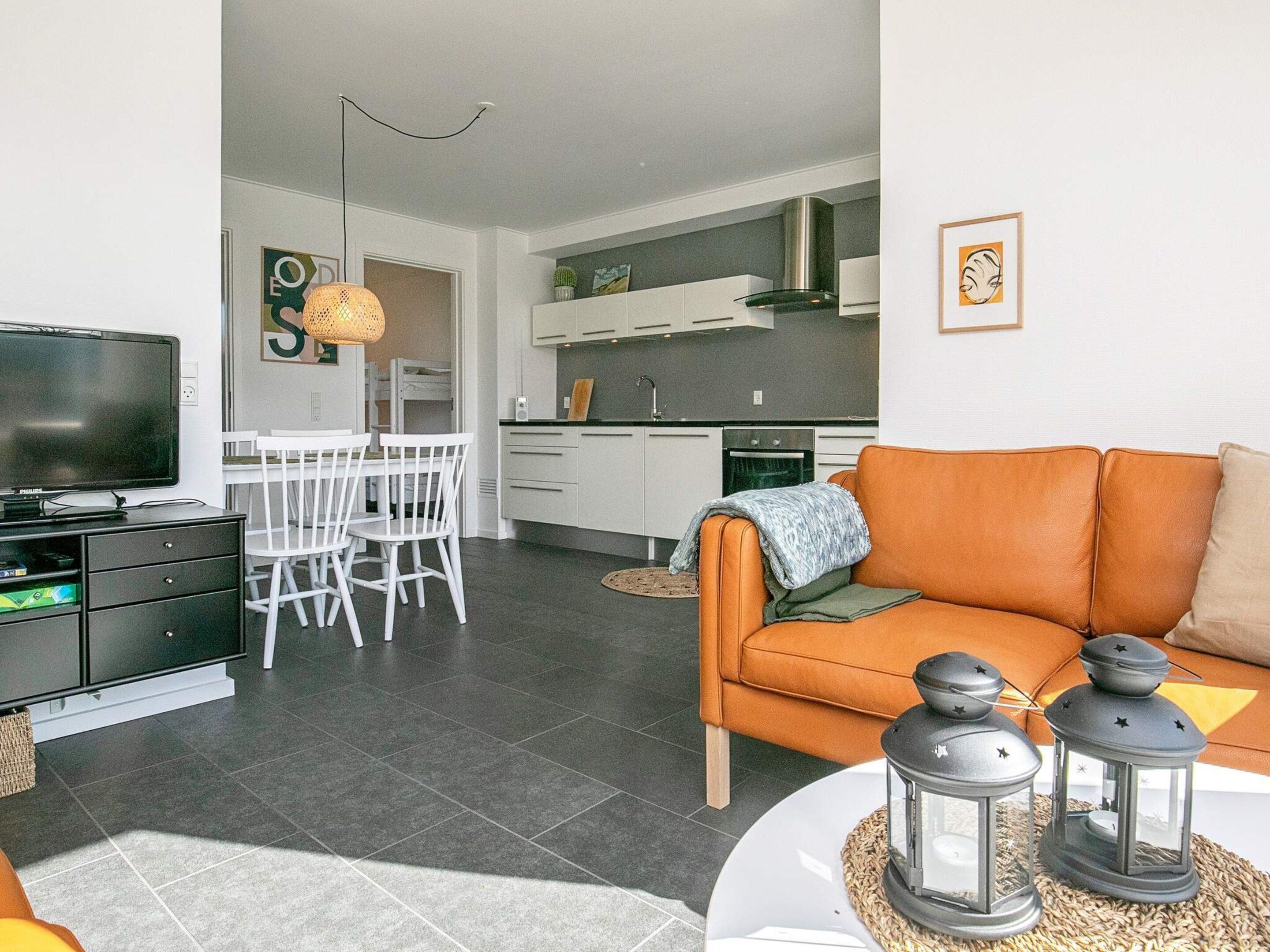 A modern living room with a television, sofa, and decorative lanterns.