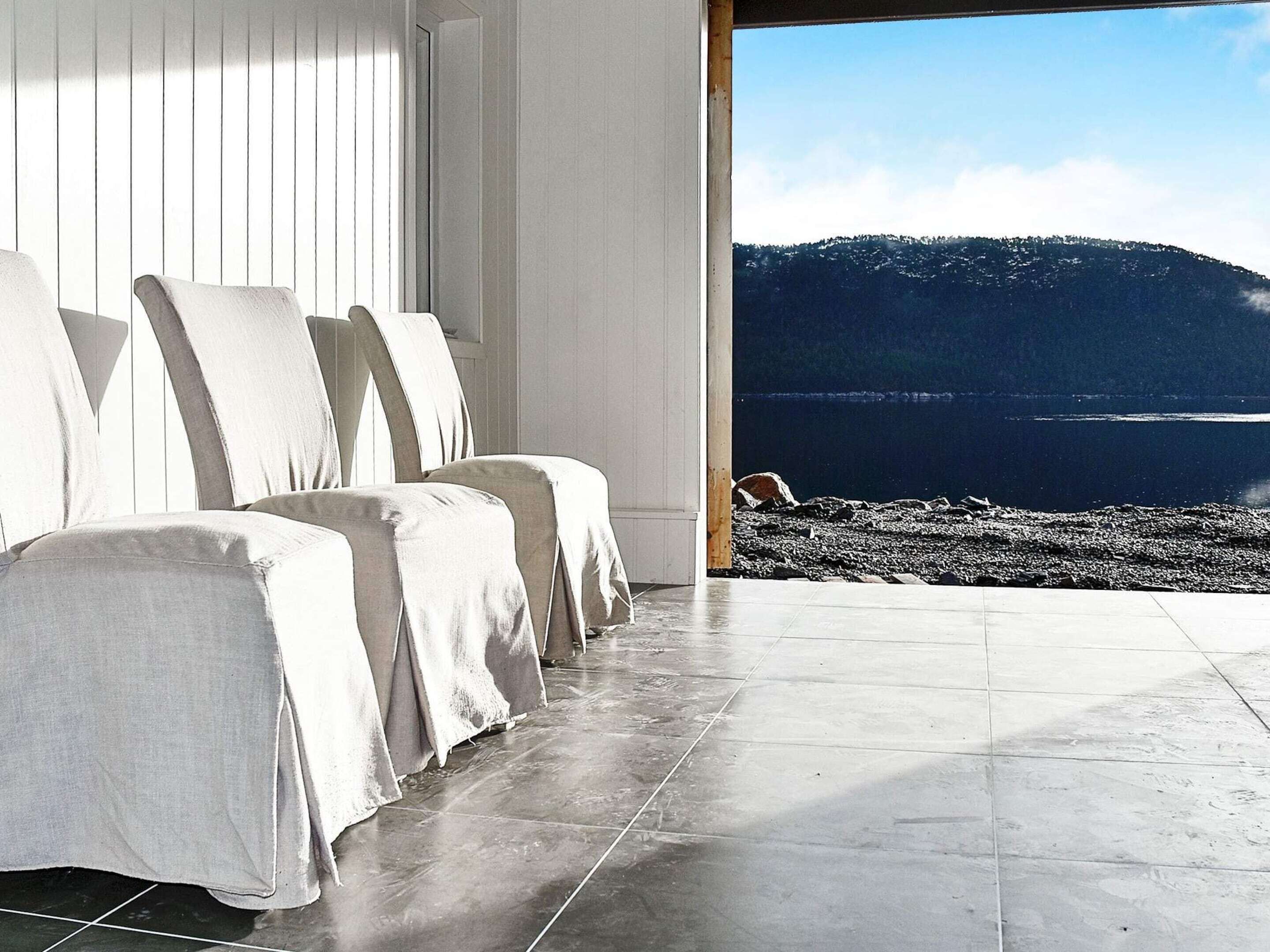 Ein modernes Zimmer mit Sitzecke und Blick auf eine felsige Küstenlinie.