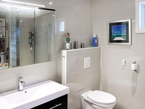 A modern bathroom with a white vanity, a toilet, a shower, and a large mirror. - 5 Person Holiday Home in Tjøme (Færder)