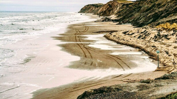 A coastal beach with a sandy shoreline, cliffs, and a clear view of the ocean. - Holiday Home in LÃ¸kken (Lokken)