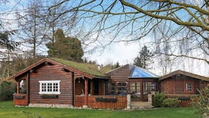 A wooden cabin with a glass roof, surrounded by a well-maintained lawn and trees. - 5 Person Holiday Home in Middelfart (Middelfart)