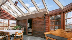 A log cabin with a dining area, a wooden bench, and a glass ceiling. - 5 Person Holiday Home in Middelfart (Middelfart)
