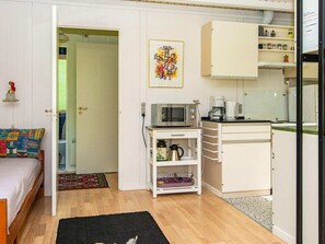 Cozy retreat with a kitchenette, featuring a bed, microwave, coffee maker, and kettle.