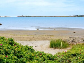 Uma praia com vista clara para a água e terra ao longe.