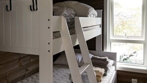 A bunk bed with a ladder, a window with a view of greenery, and a wooden floor. - 6 Person Holiday Home in Kalvag (Bremanger)