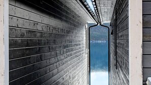 A wooden cabin with a view of a lake through an open door. - 4 Star Holiday Home in Vatne (Ålesund)