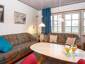 A room with two patterned sofas, a round table with two glasses, and a window with curtains. - 4 Person Holiday Home in Nordborg (Nordborg)
