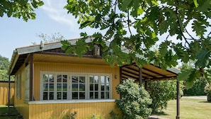 A wooden house with a covered porch, large windows, and a well-maintained lawn. - 4 Person Holiday Home in Nordborg (Nordborg)