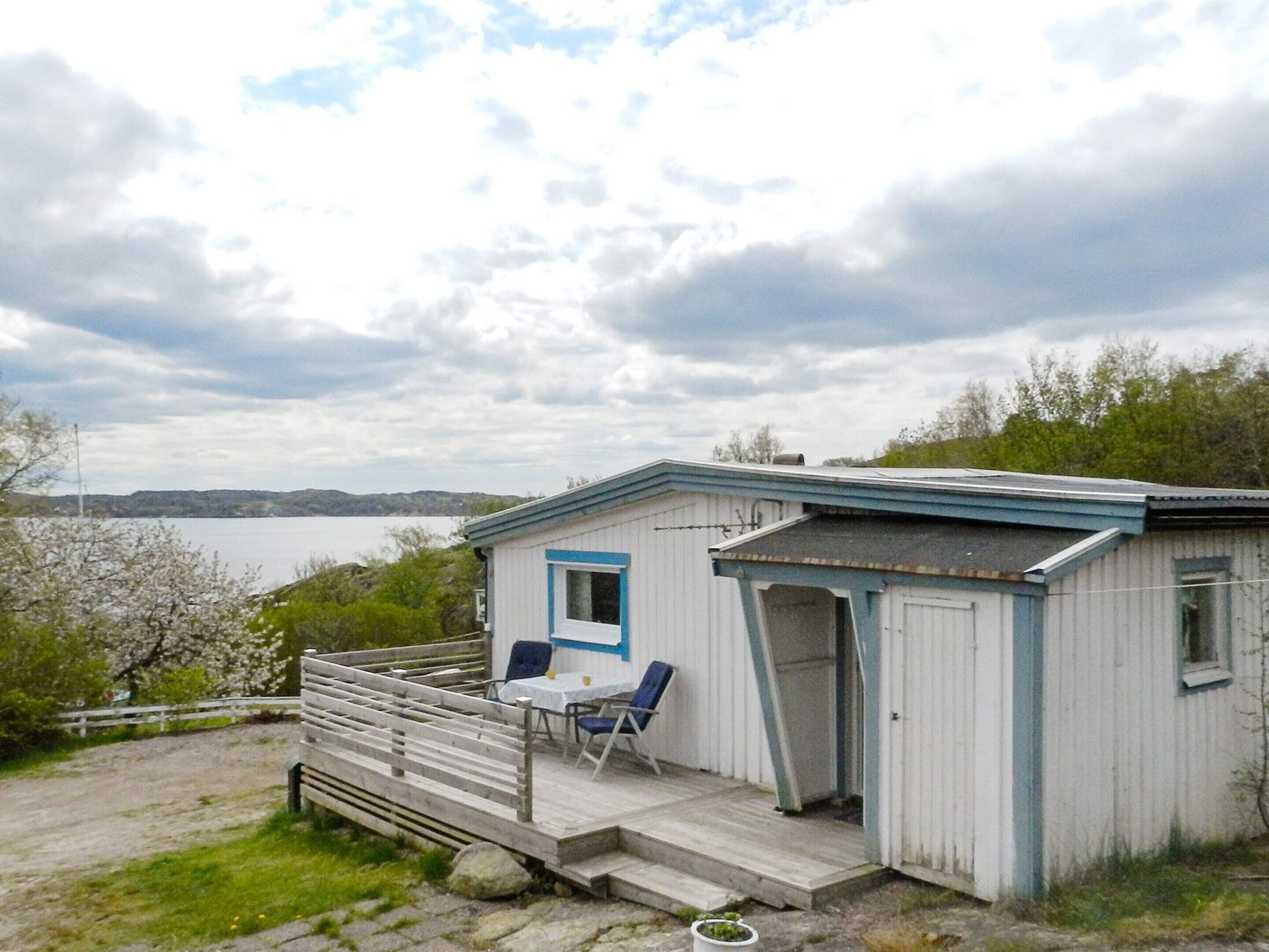 A small cabin with a porch, a table, and two chairs.
