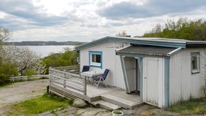 A small cabin with a porch, a table, and two chairs. - 4 Star Holiday Home in Lysekil (Lysekil)