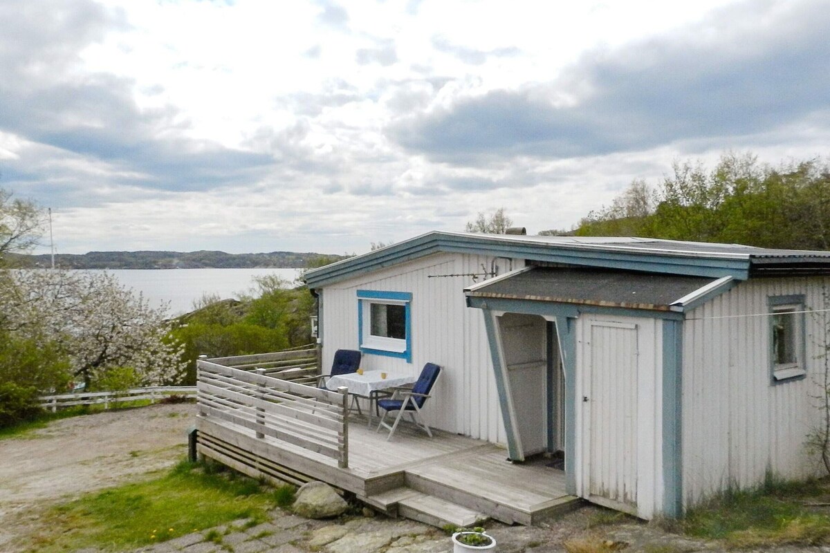 A small cabin with a porch, a table, and two chairs.