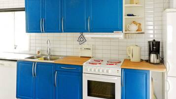 A kitchen with blue cabinets, a white stove, and a coffee maker.
