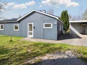 A single-story building with a grey exterior, a white door, and a small attached garage. - 6 Person Holiday Home in Ebeltoft (Ebeltoft)
