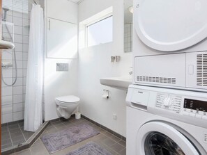 A modern bathroom with a toilet, a washing machine, and a shower. - 6 Person Holiday Home in Ebeltoft (Ebeltoft)