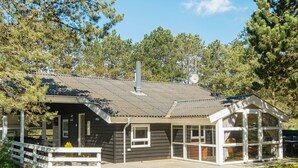 A cabin with a deck, large windows, and a chimney. - 4 Star Holiday Home in Ebeltoft (Ebeltoft)