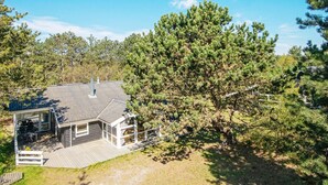 A house with a deck, a covered patio, and a large tree in the yard. - 4 Star Holiday Home in Ebeltoft (Ebeltoft)