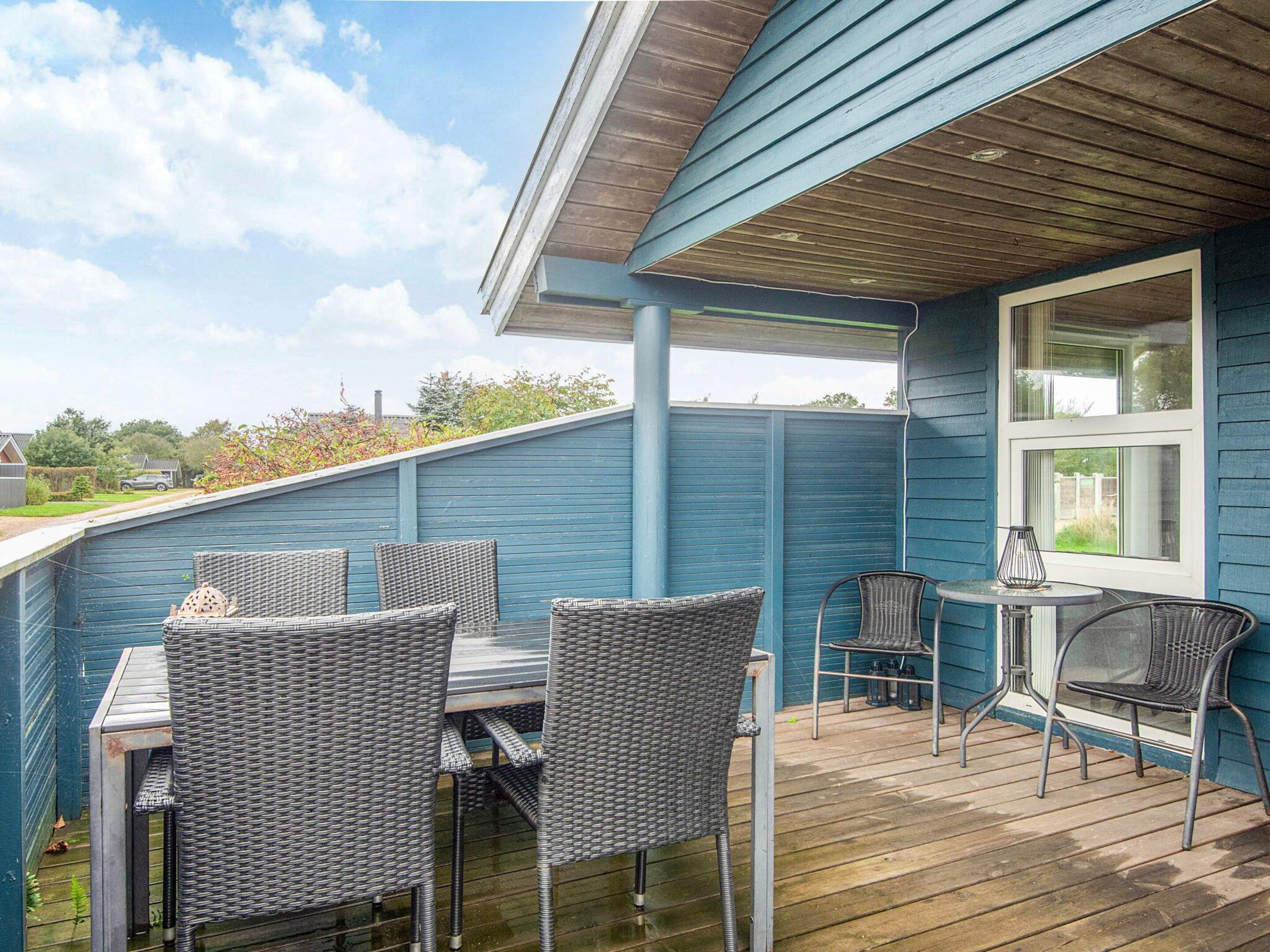 A covered outdoor patio with wicker furniture and a table.