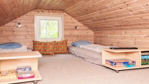 A small attic bedroom with two beds, a window, and a shelf with board games. - 4 Person Holiday Home in Hemmet (Hemmet)