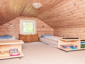 A small attic bedroom with two beds, a window, and a shelf with board games. - 4 Person Holiday Home in Hemmet (Hemmet)