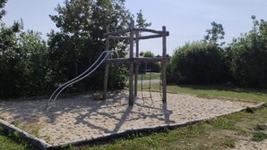 A playground with a wooden climbing structure and a slide. - 4 Person Holiday Home in Hemmet (Hemmet)