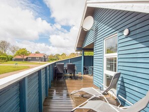 A blue building with a covered deck area, outdoor furniture, and a satellite dish. - 4 Person Holiday Home in Hemmet (Hemmet)