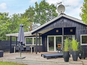 A modern wooden cabin with a satellite dish, outdoor seating, and potted plants. - 4 Star Holiday Home in Hadsund (Hadsund)