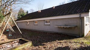A building with a tiled roof, a small window, and a wooden deck. - 5 Star Holiday Home in Glesborg (Glesborg)