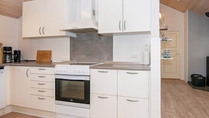 A modern kitchen with white cabinetry, a built-in oven, and a gas stove.