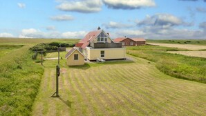 A single-story house with a sloped roof, a small attached garage, and a well-maintained lawn. - 12 Person Holiday Home in Lemvig (Lemvig)
