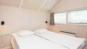 A double bed with white bedding in a room with wooden walls and ceiling. - 8 Person Holiday Home in Otterup (Otterup)