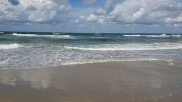 A beach with waves and a clear sky.