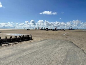 A beach with a sandy area and a paved path.