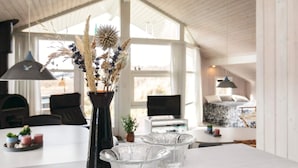A modern interior with a white table, a black vase with dried flowers, and clear glass vases. - Spacious Holiday Home Nearby the National Park Loonse en Drunese Duinen (Hjørring)