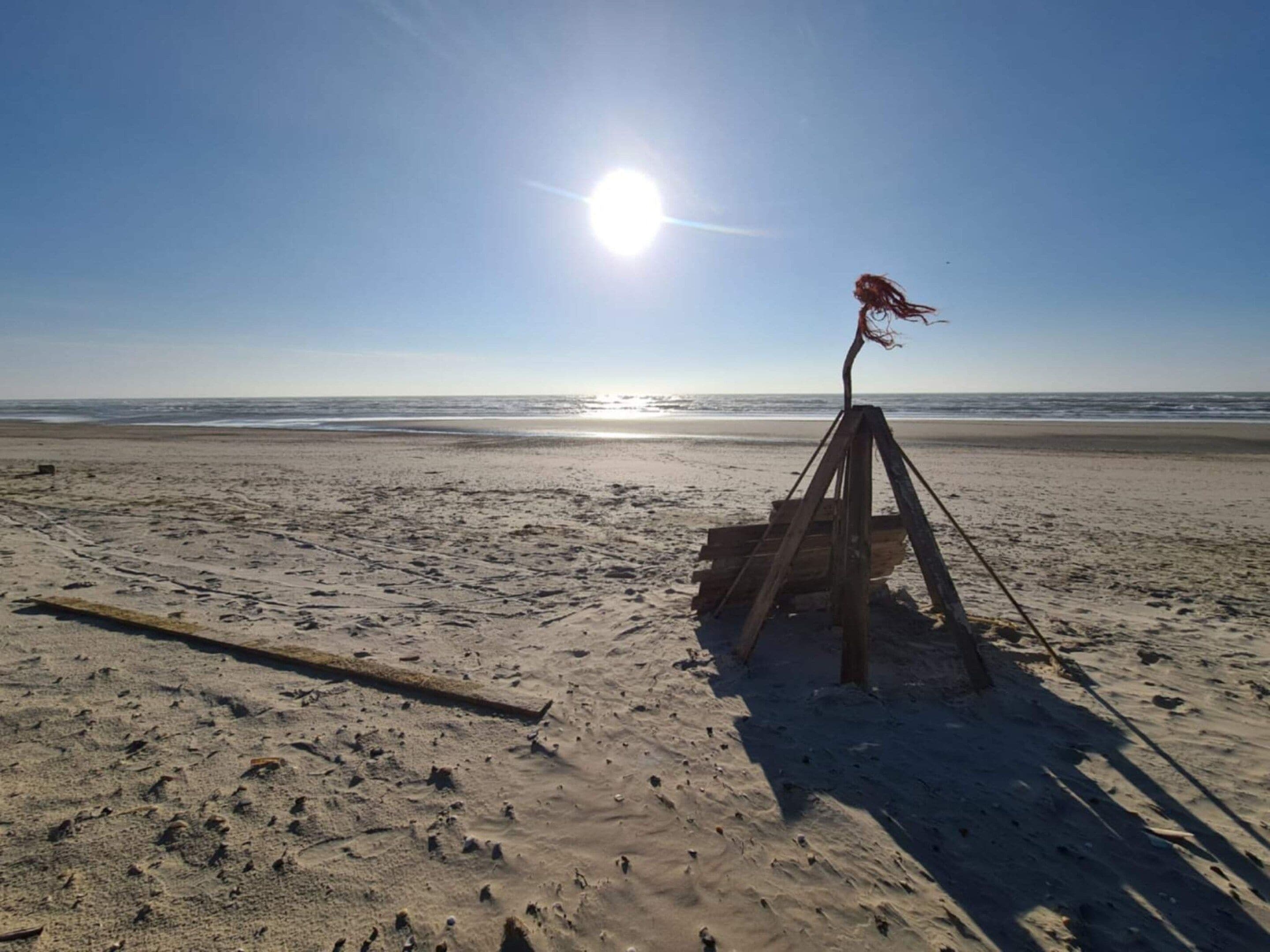 A beach with a wooden structure, possibly a lifeguard stand, and the ocean in the background.