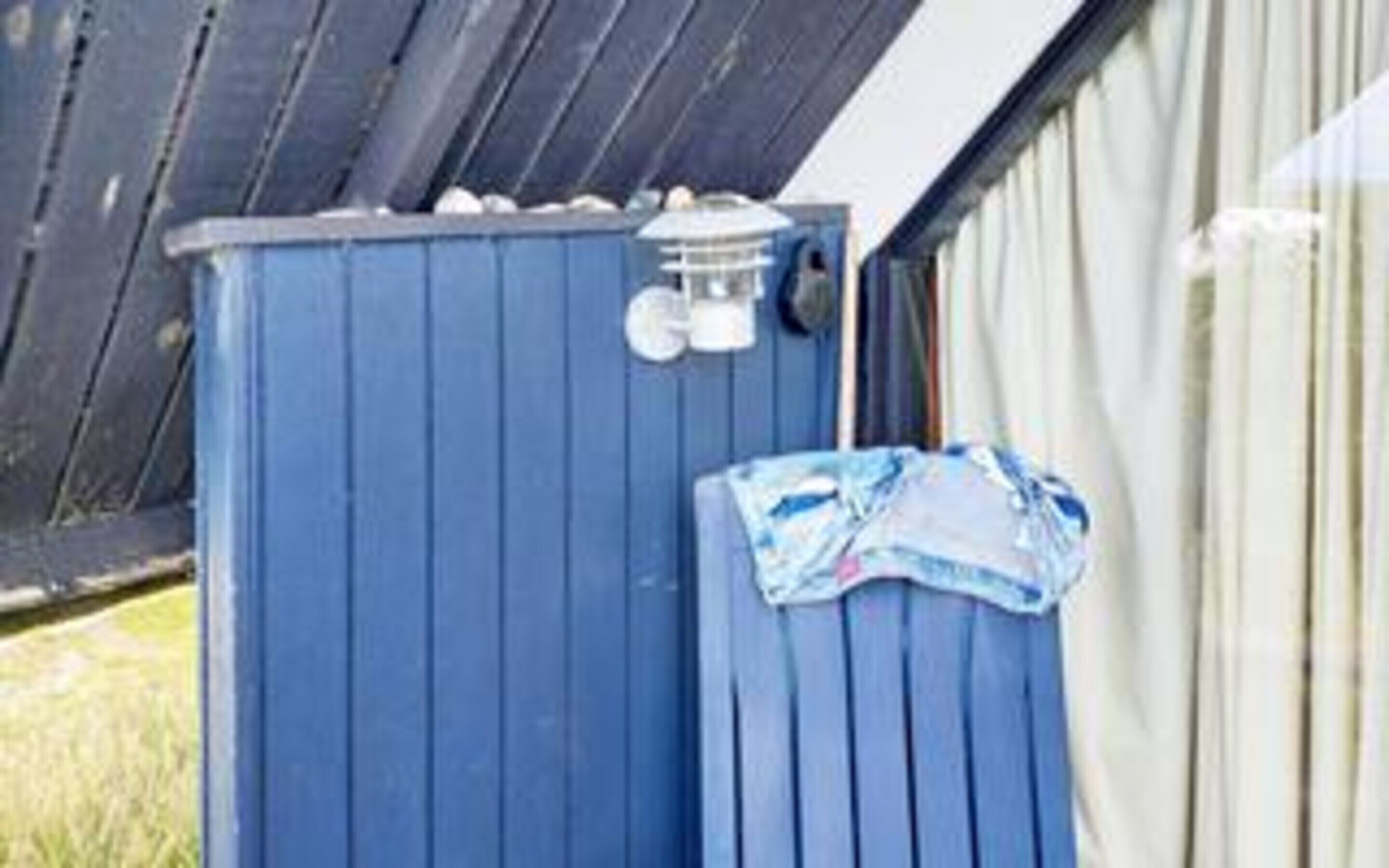 A blue outdoor unit, possibly a water heater, with a white pipe attached.
